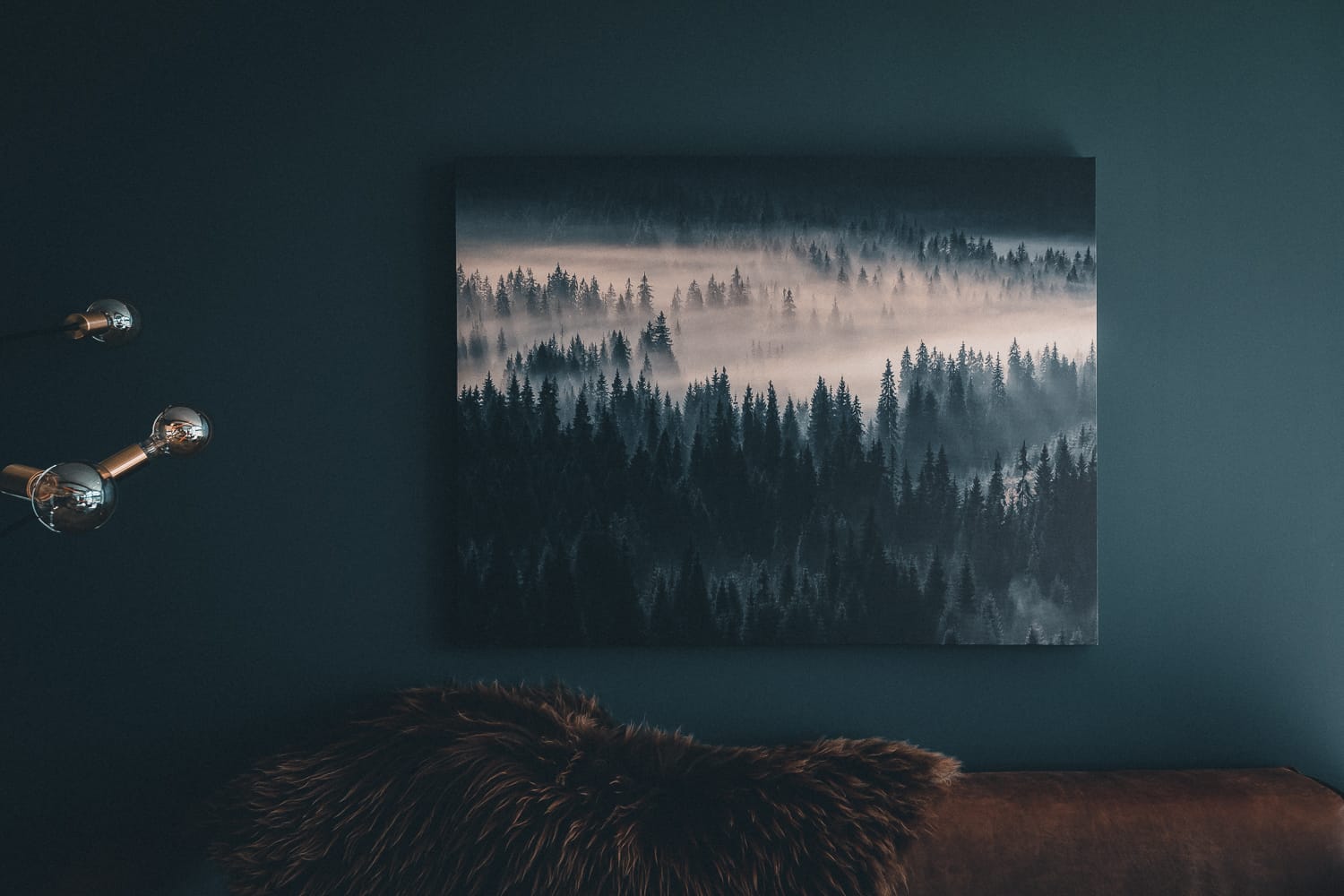 leather couch with a forest painting on the wall